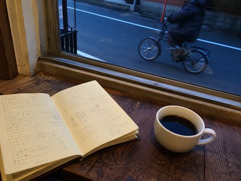 千駄木咖啡店窗邊的筆記本、咖啡與經過的單車