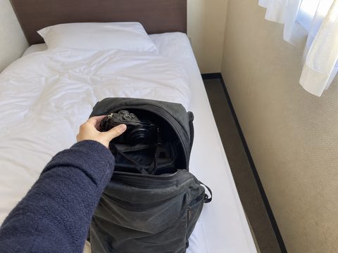 主角在淺草小旅館把相機放進日用背包