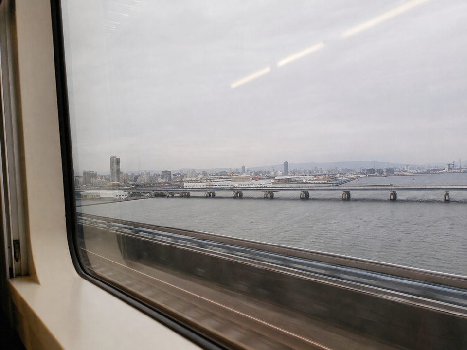 南海電車窗外灰色的灣岸與橋