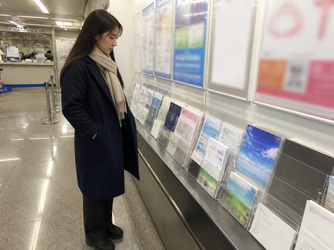 在旅行資訊海報前重新計算回程