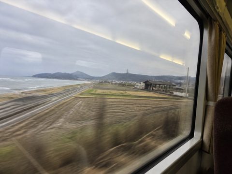 山陰本線車窗外的海、田地與低山