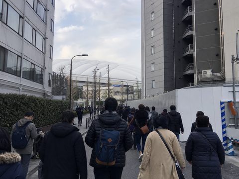 從水道橋步行途中在人潮與建物間看見東京 Dome 白色屋頂